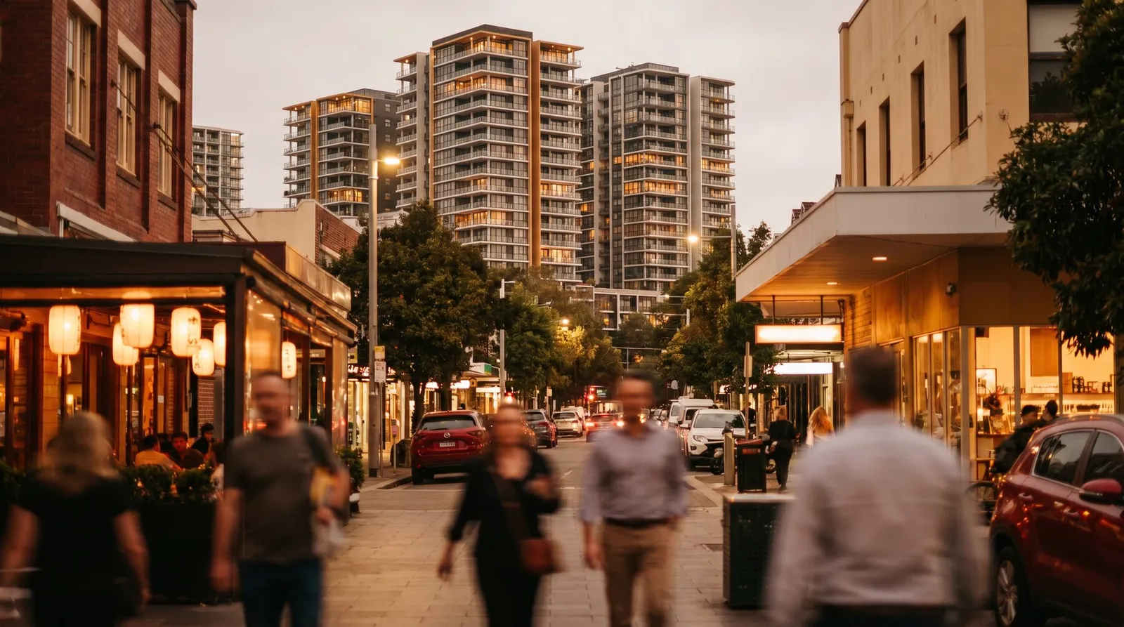 Apartment towers above the lantern-lit Burwood Road strip at dusk